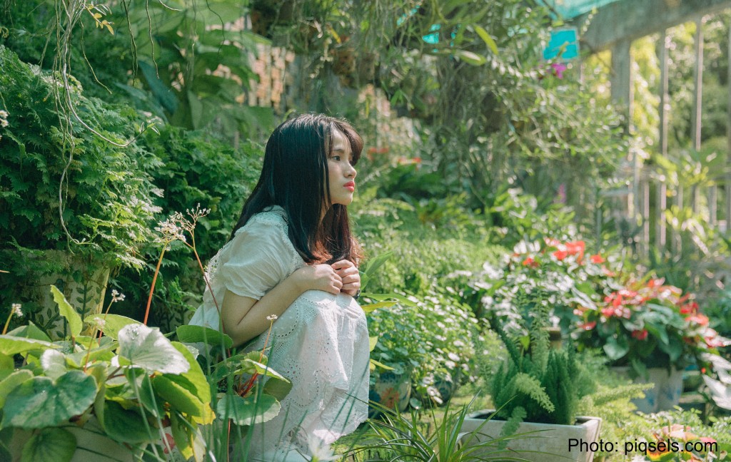Pensive woman in flower garden.